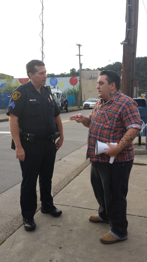 Eli Kuti (r) talks with a police officer from Pittsburgh ahead of an LGBTQ Rally