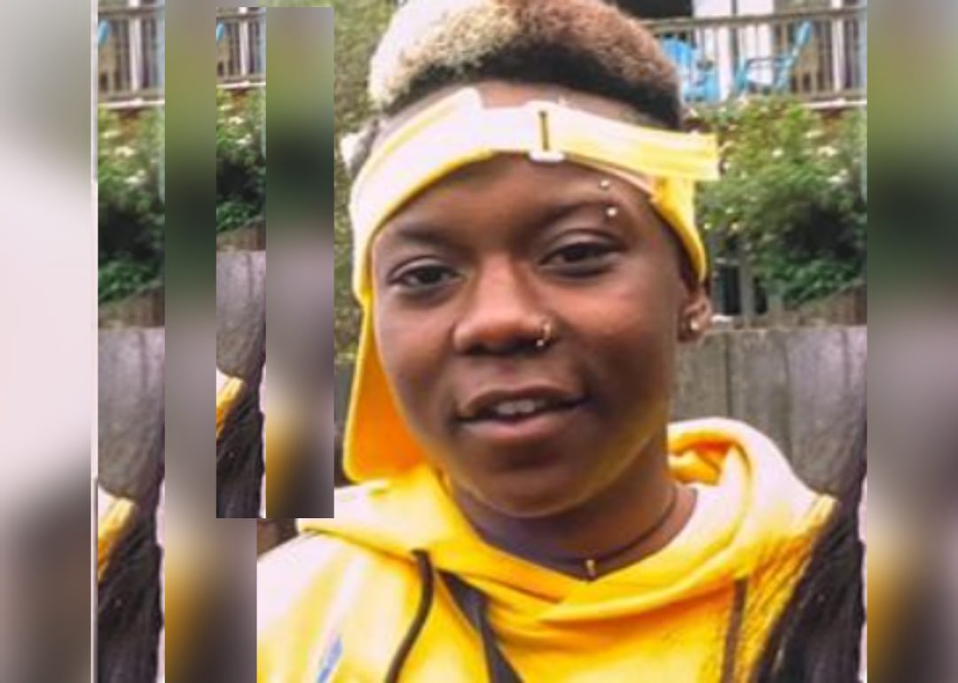 headshot of a young Black man wearing a yellow sweatshirt and a yellow viser upside down