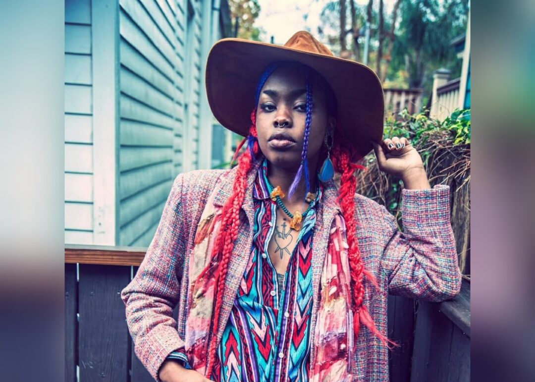 Black nonbinary artists in colorful clothing. Unknown source.