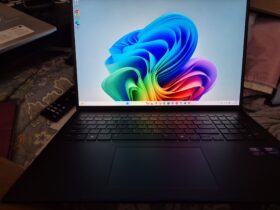 photo of a bllack laptop with a multicolor flower as the screensaver